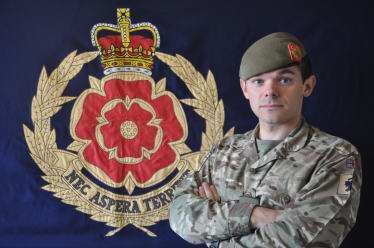 Paul in uniform in front of his Regimental Flag